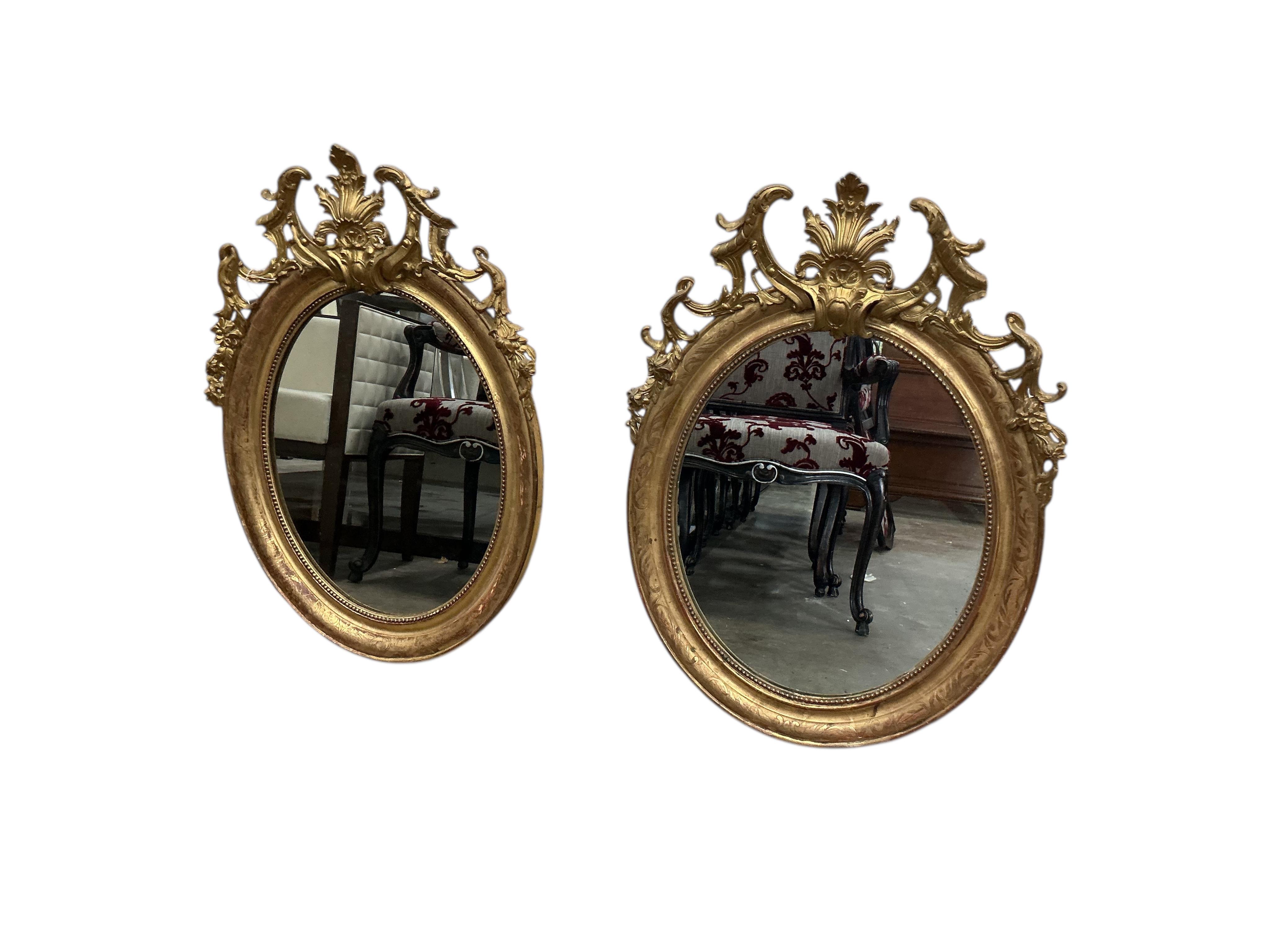 A pair of 19th century French giltwood and composition oval wall mirrors, width 68cm, height 91cm